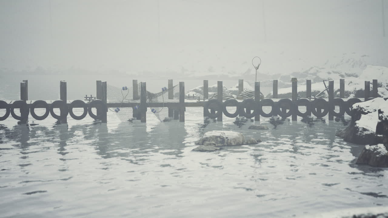Frozen dock at a remote location during winter in a misty atmosphere