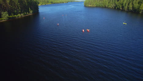 flying over a group of people out kayaking on a river on a sunny day