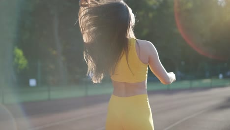 woman running on outdoor track in yellow sportswear