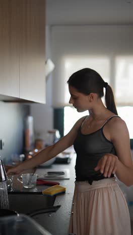 joven lavando platos en la cocina