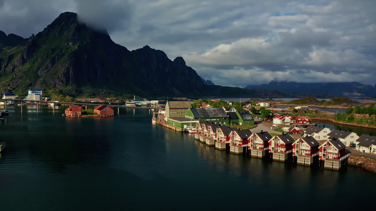 Aerial drone shot over Svolvaer, Lofoten Islands, Norway.
High view of the fishermen cabins and the scenic nordic landscape at sunset.