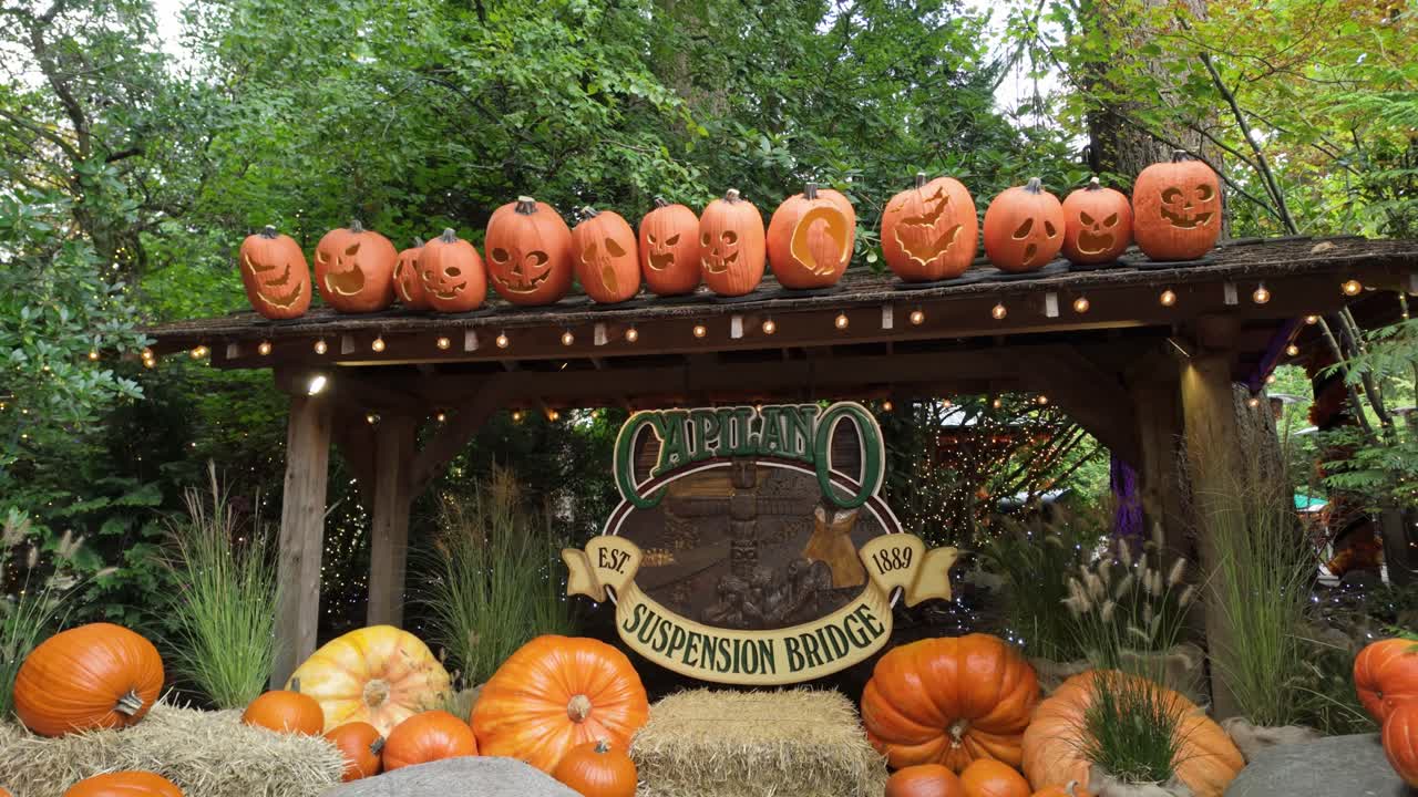 Gimbal close booming down shot of the Capilano Suspension Bridge Park entrance signage decorated for Halloween in North Vancouver, British Columbia, Canada. 4K at 30 FPS