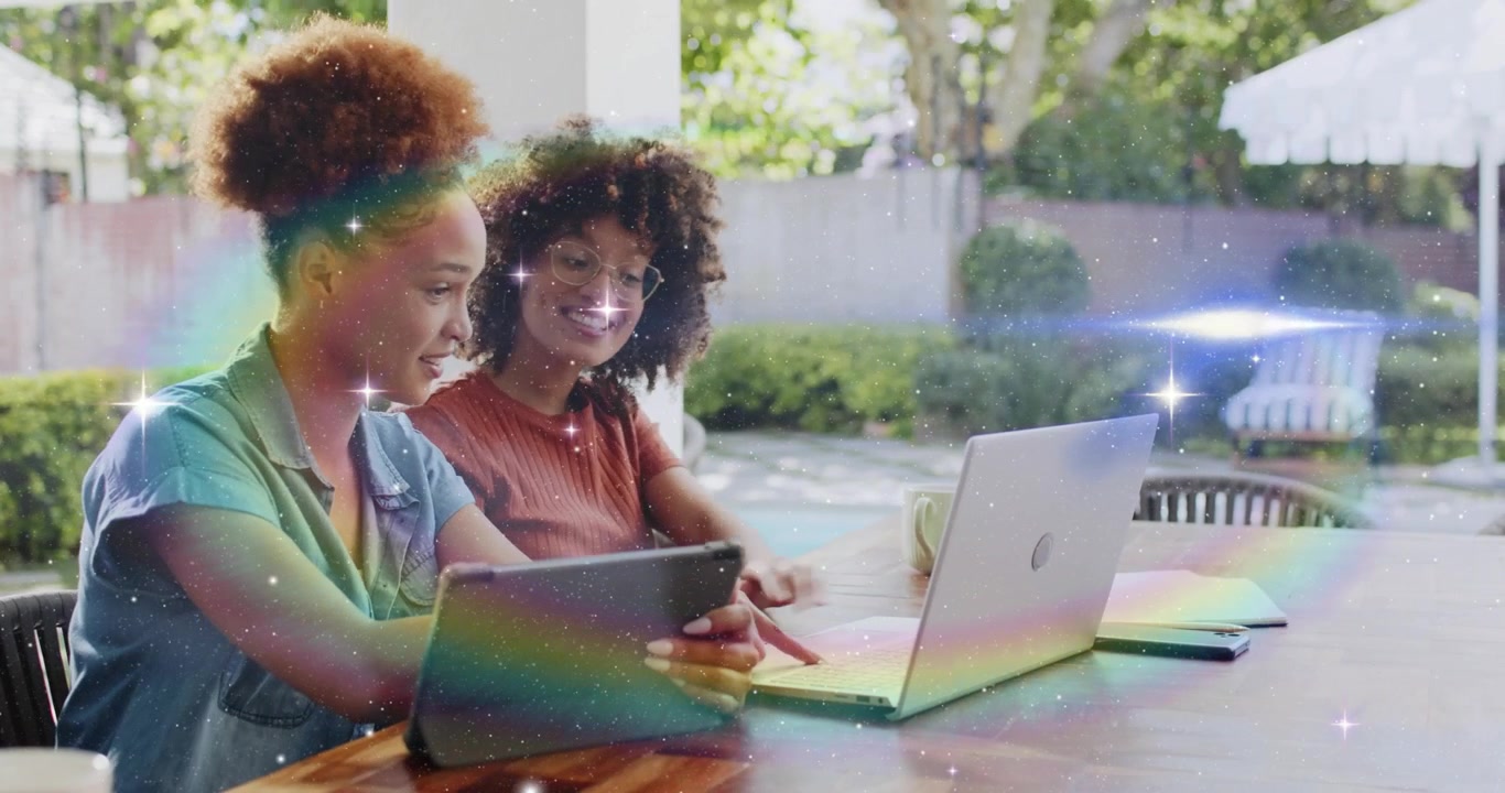 Tablet tapping by marketing designers initiating sparkles then sliding laptop while editing content