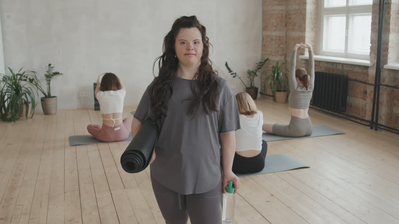 Portrait Of Young Woman With Down Syndrome Holding Yoga Mat