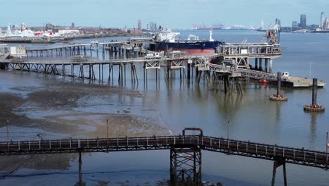 Crude-oil-tanker-ship-loading-at-refinery-harbour-terminal-platform-aerial-view-dolly-right-low