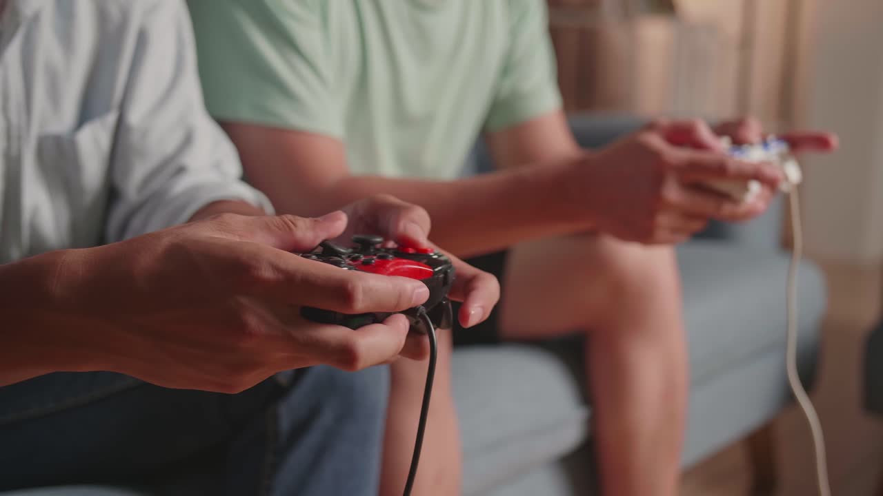 Close Up Hands Of Two Males Holding Joystick And Playing Video Games