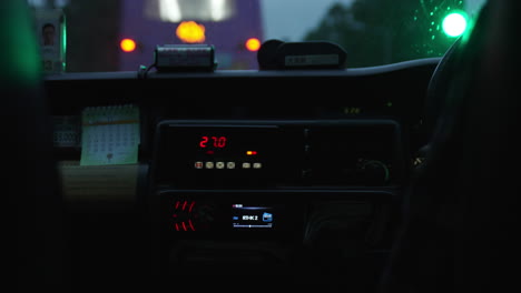 un taxímetro o medidor de tarifas instalado en un taxi que circula por la ciudad moderna