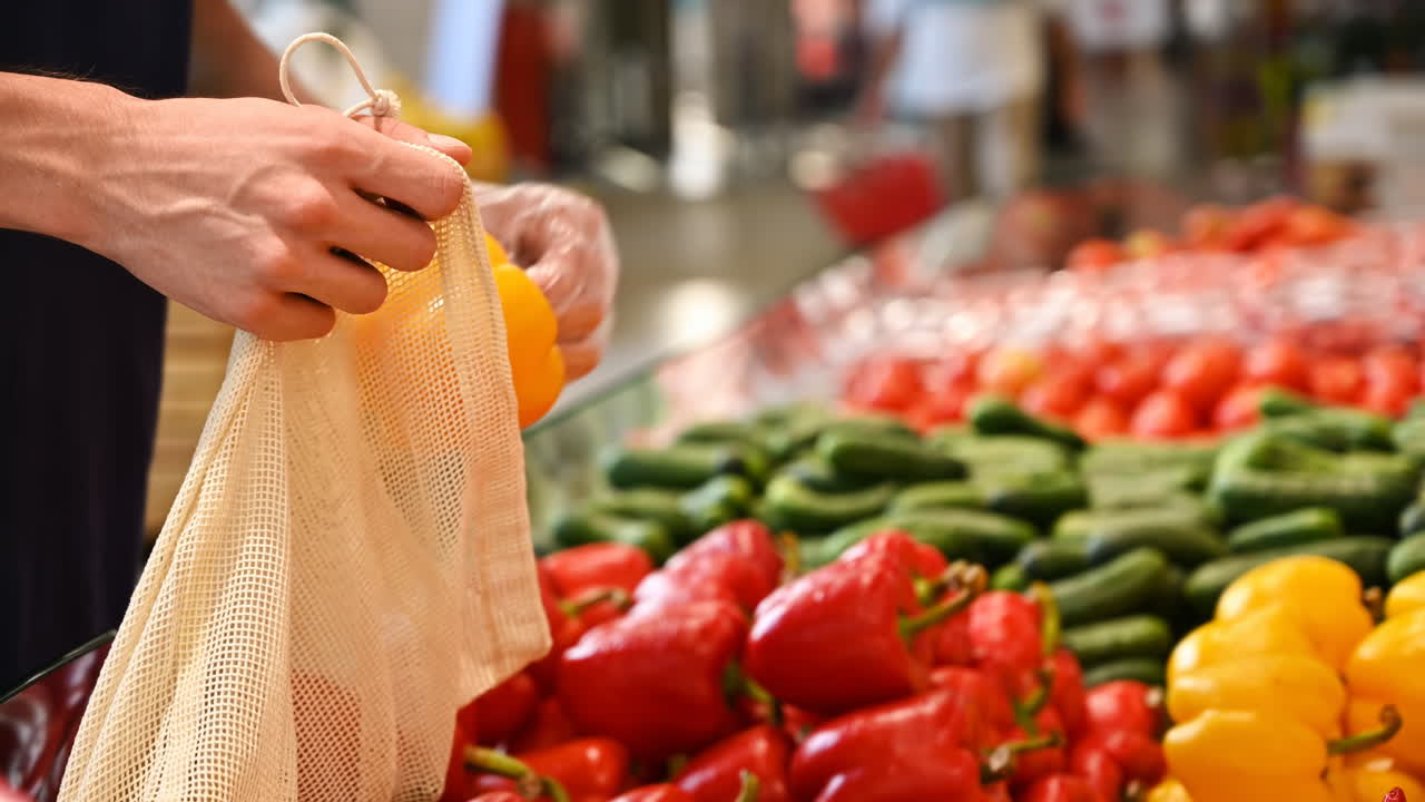 Man's hands putting papers in a reusable ecological bag in the supermarket. Slow motion. Ecology idea. Slow motion