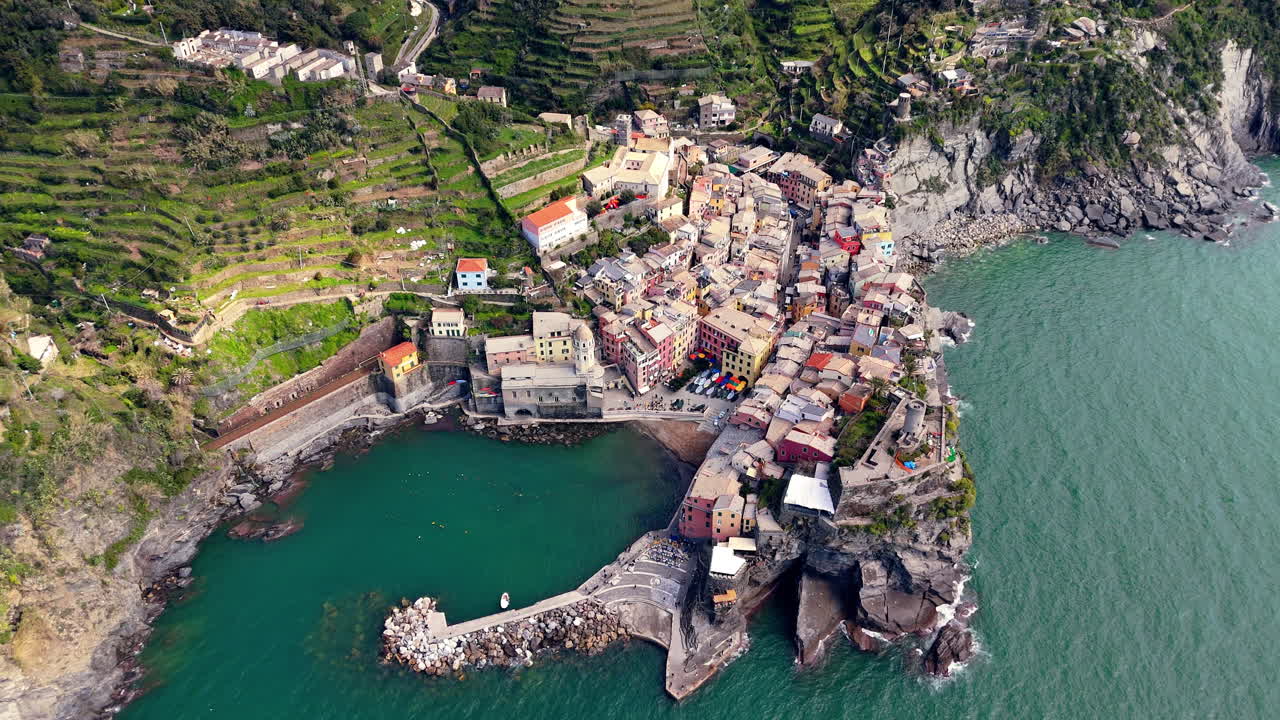 Vernazza in cinque terre, italy showcasing the coastline, colorful houses, and lush green hills, aerial view