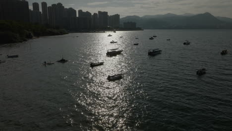 aerial-cityscape-at-sunset-with-skyscraper-modern-building-and-boat-moored-at-honk-kong-main-port-pier