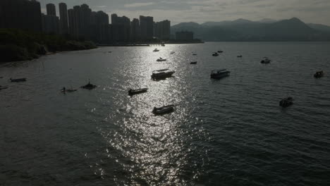 Paisaje-Urbano-Aéreo-Al-Atardecer-Con-Un-Edificio-Moderno-De-Rascacielos-Y-Un-Barco-Amarrado-En-El-Muelle-Del-Puerto-Principal-De-Honk-Kong