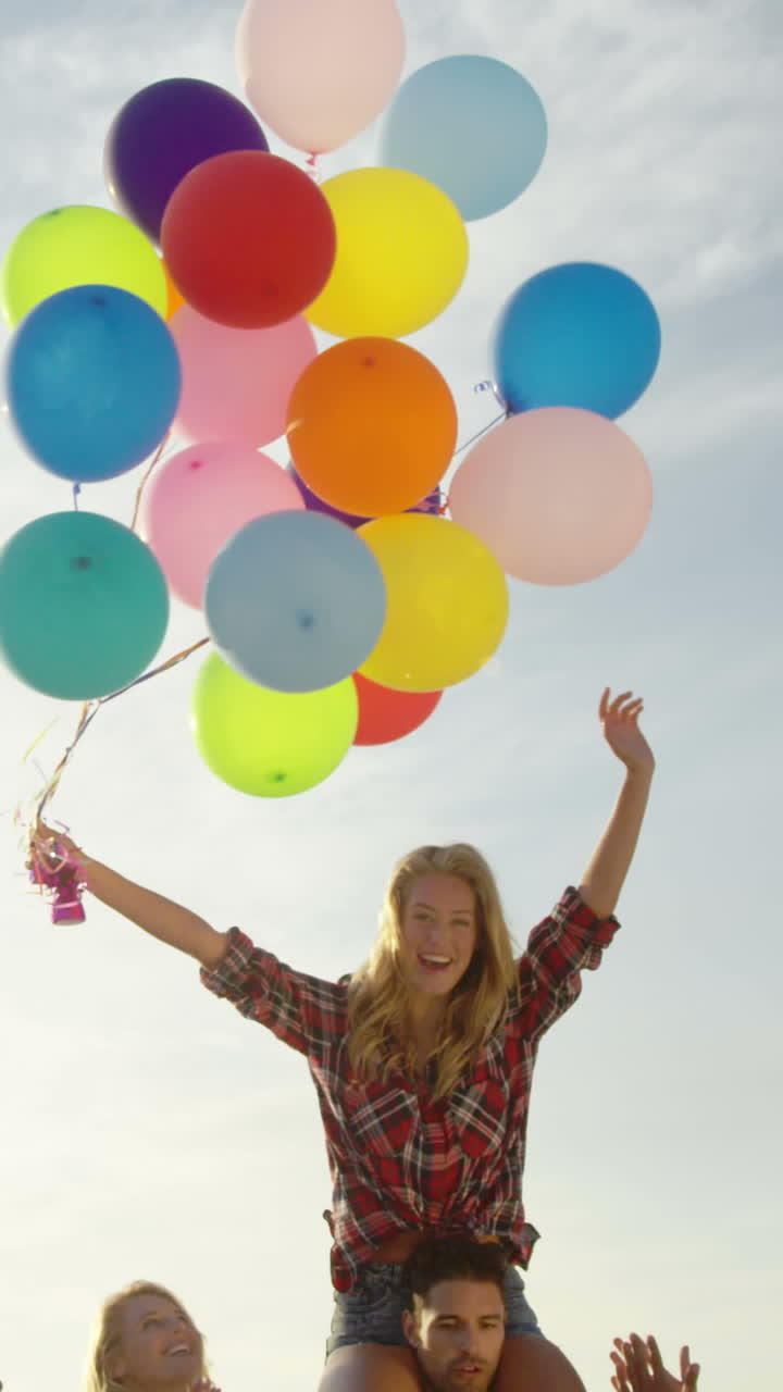 amigos bailando en la arena con un globo