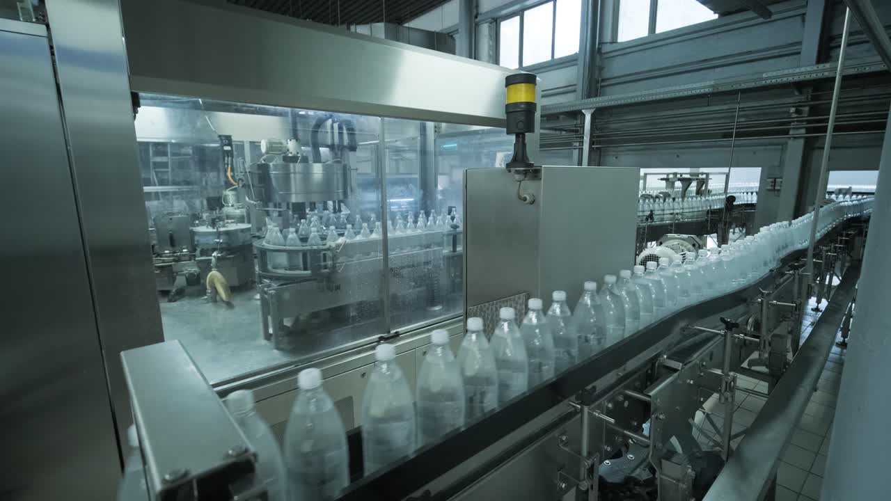 cinta transportadora con botellas de agua potable en una planta de bebidas moderna