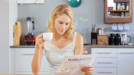 woman drinking coffee and reading newspaper