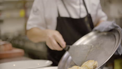 un hombre cocina un delicioso plato de pescado en el centro de madrid en un restaurante de lujo