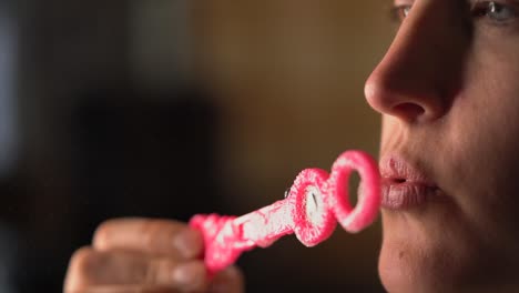 closeup macro lips blowing bubbles from pink bubble wand