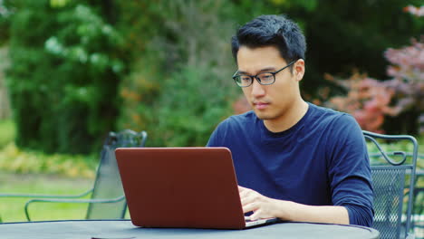 A-Young-Asian-Man-Works-With-A-Laptop-4