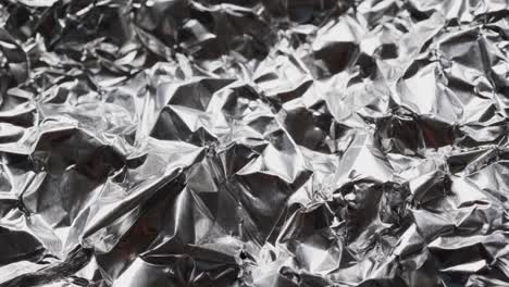 close up of silver crumpled shiny aluminium in slow motion