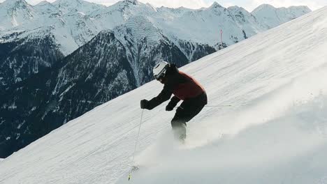 ski professional skiing downhill on a steep black ski slope with beautiful mountain landscape view in the tyrolean alps