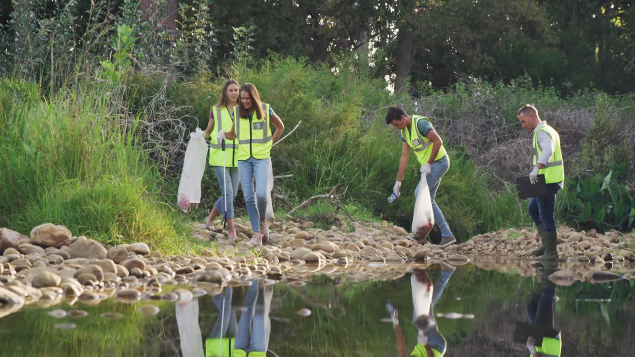 Mid adult with yellow vest volunteering during river clean-up day