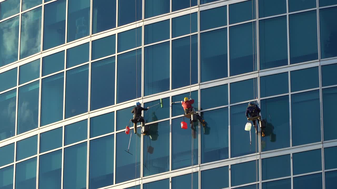 los lavadores de ventanas en los rascacielos en el trabajo,