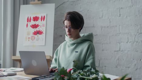 woman artist working on laptop in creative studio