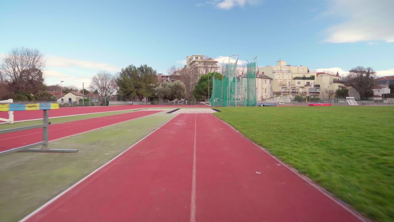 pov, punto de vista del atleta tiro de salto largo o salto ancho con aterrizaje en la arena, en un estadio olímpico en un día soleado, carrera de práctica
