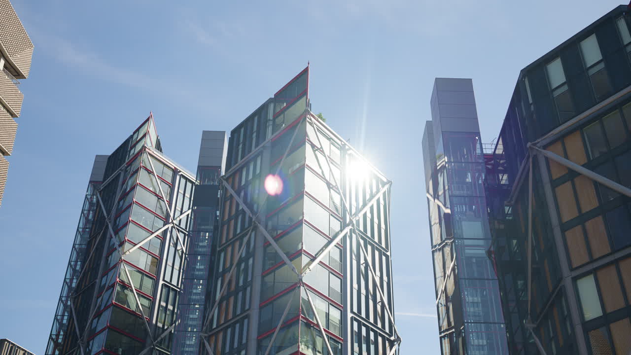 View of a modern glass office buildings in London, England with sunlight reflecting off windows