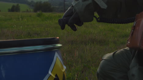 A-man-in-a-protective-suit-with-a-dosimeter-inspects-a-barrel-with-a-warning-label-reading-radioactive