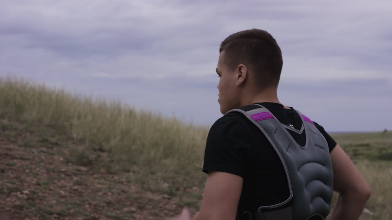 자연에서 웨이트 베스트를 입고 달리는 남자