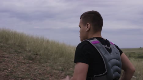 hombre corriendo con chaleco de peso en la naturaleza