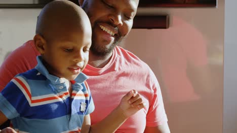 father and son having food at dining table at home 4k