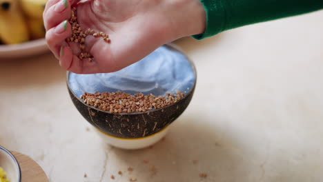 mujer, mano y migas en un tazón de muesli para la dieta