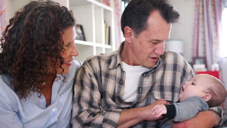 Abuelos-Sentados-En-El-Sofá-Jugando-Con-Su-Nieto-En-Casa