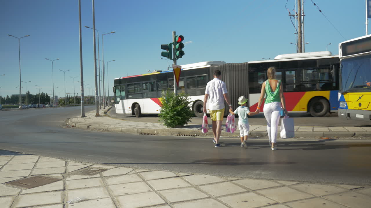 familia con bolsas de compras cruzando la carretera