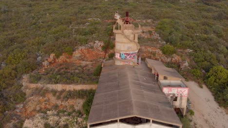 Abandoned-quicklime-factory-on-a-hill,-aerial-moving-towards-from-a-high-angle