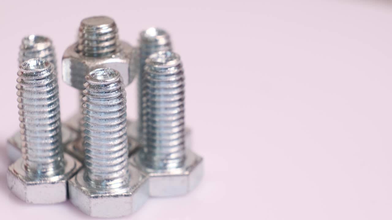 grupo giratorio de tornillos metálicos galvanizados de primer plano. pernos de acero inoxidable aislados sobre un fondo blanco.