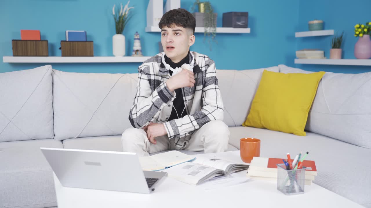 집에서 공부하려고 하는 우울한 십대가 울고 있습니다.