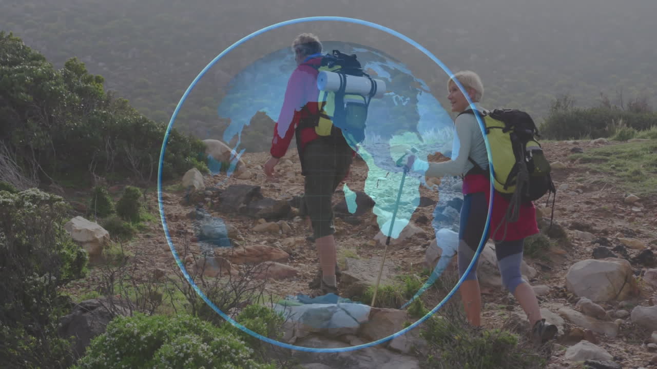 Adult man and woman hikers climbing rocky trail with packs, poles, showing digital Earth globe tech