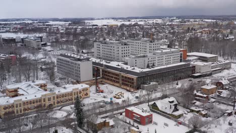 Drohnenaufnahme-Des-Krankenhauses-Tartus-Maarjamõisa-Im-Winter,-180-Grad-Aufnahme-Davon