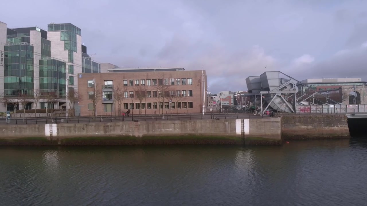 Un ciclista pedala lungo le rive del fiume Liffey, Dublino, Irlanda.