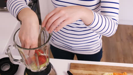 Close up on a woman preparing a smoothie 