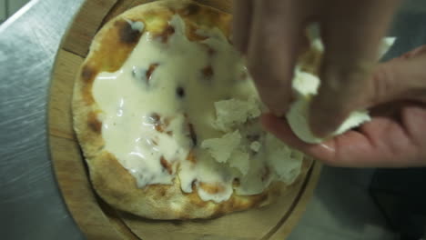 making a pizza with white sauce and mozzarella