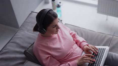 Relaxed-Woman-Working-With-Laptop-Computer-And-Listening-Music-By-Headphone