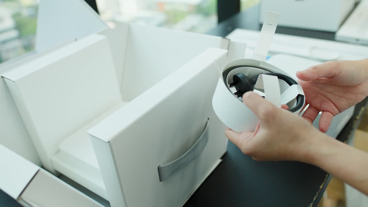 Hands remove and examine power cable from white desktop computer box in bright, natural lighting