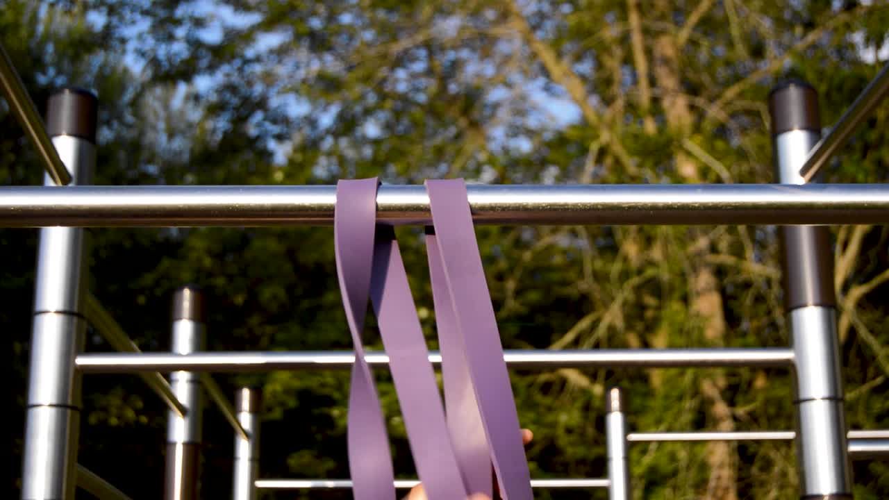 막대에 저항 밴드를 당기는 손