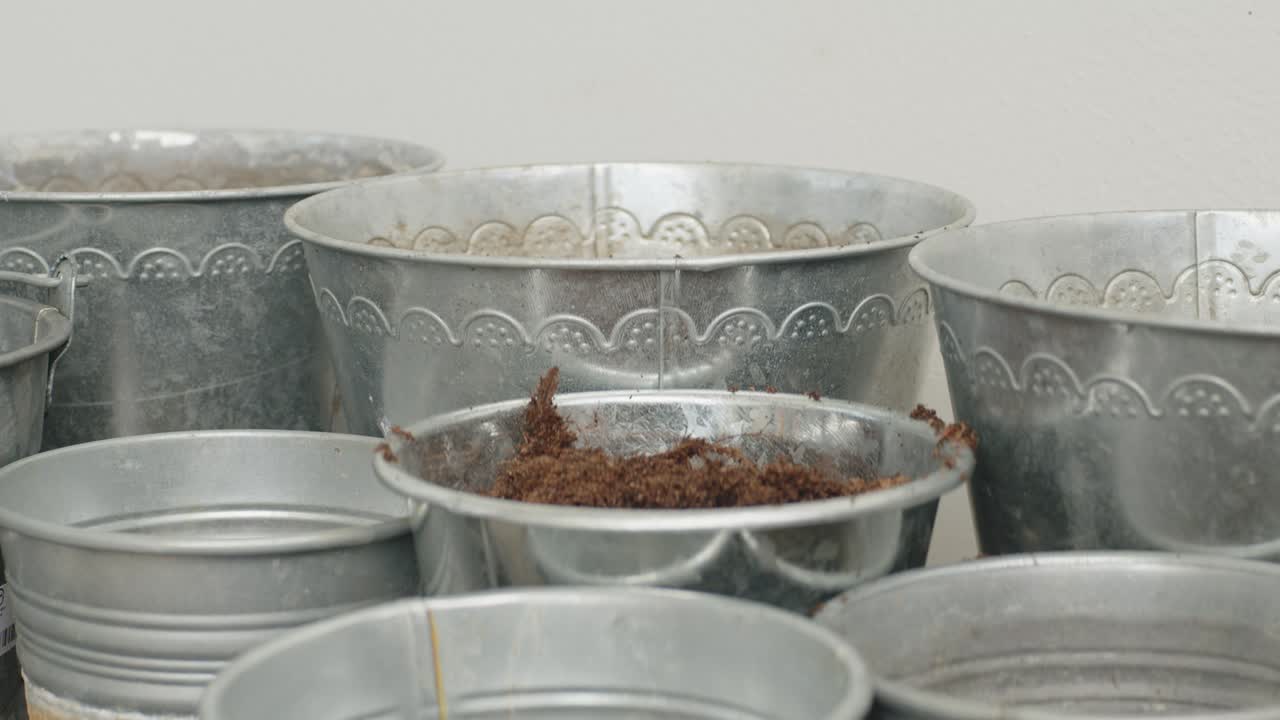 The buckets are being filled with soil, as the earth is poured or scooped into them