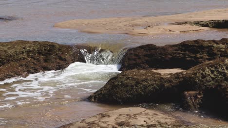 water flowing from ocean over rockpool at high tide 4k