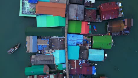 Aerial view of the colorful stilt houses of bang bao pier in koh chang, thailand, showing poverty and overpopulation. Tremendous aerial view flight vertical bird's eye view ascending drone