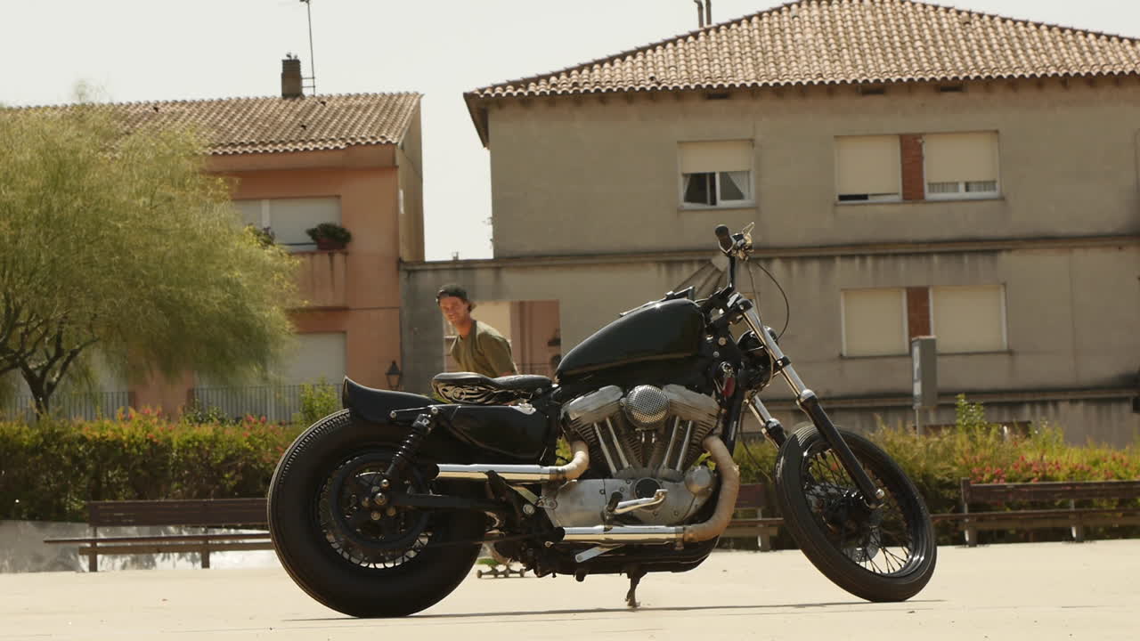 Skater performing trick switch ollie with motorcycle in background under harsh sunlight